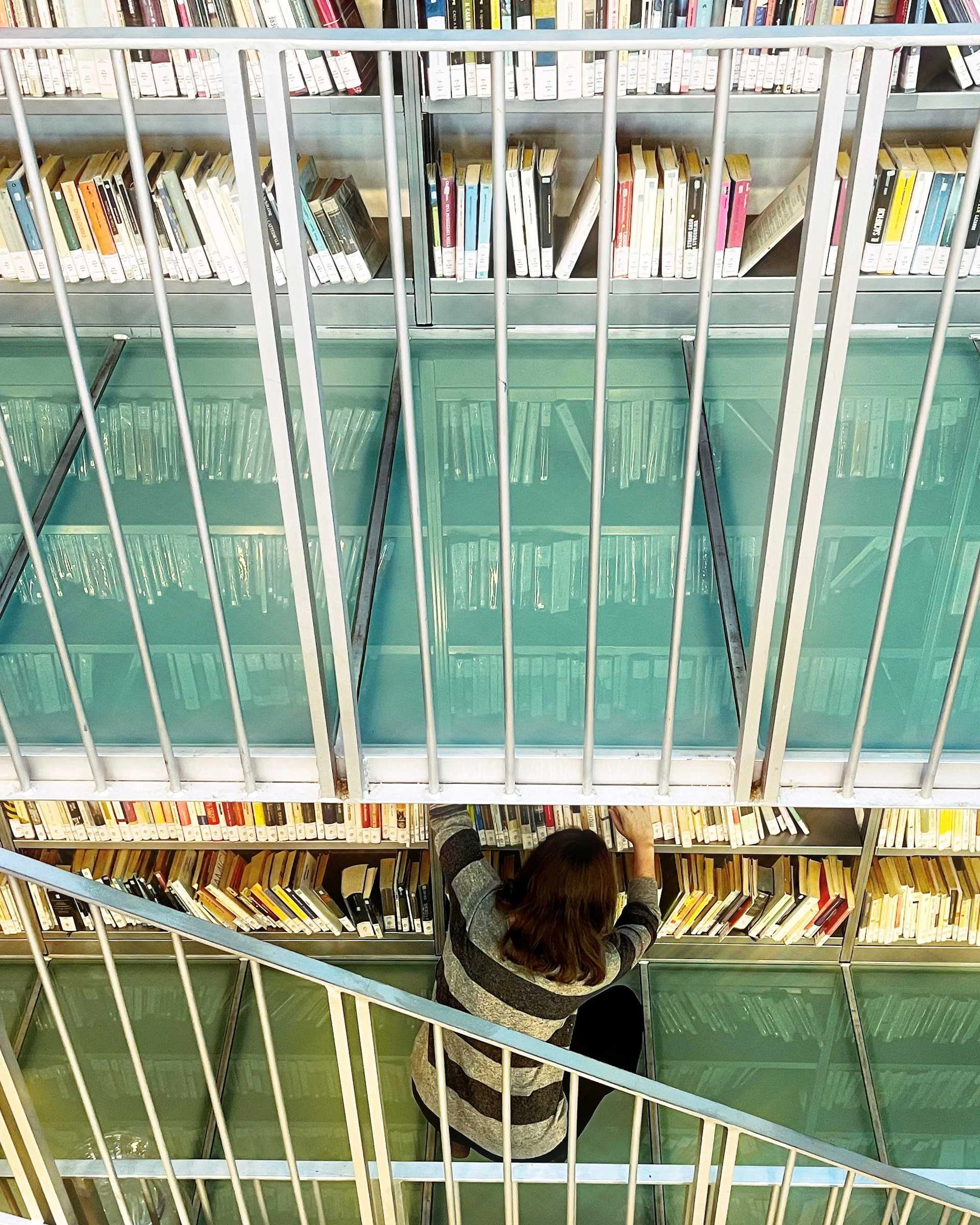 Maria Chiara Tamani di fronte a una parete di libri in biblioteca